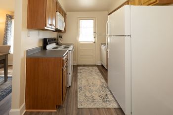 A kitchen with a white fridge and wooden cabinets.